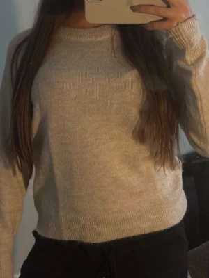 Beige stickad tröja från Selected Femme - Super fin och mysig beige stickad tröja från Selected Femme med rund halsringning och långa ärmar, som är helt ny och aldrig kommit till användning och förtjänar en ny garderob. Tröjan har ribbade muddar vid ärmslut och nederkant. Perfekt basplagg i garderoben och enkel att matcha till olika outfits.