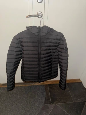 Colmar Jacka - Säljer en svart dunjacka från Colmar med huva och dragkedja framtill. Jackan är näst in till oanvänd och i helt perfekt skick!                                       Nypris: 3800kr