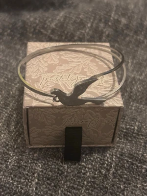 Edblad armband med fågelmotiv - Stilrent armband i silverfärgad stål metall med en elegant fågelsilhuett som detalj. Tunt och minimalistiskt band som ger en modern känsla. Perfekt accessoar för dig som gillar enkla men snygga smycken.