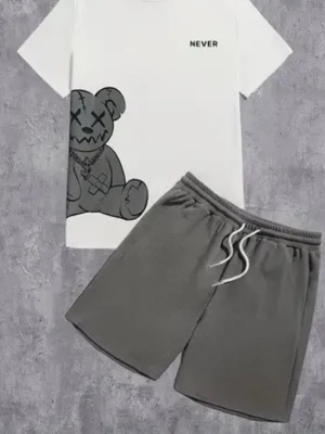 Set med t-shirt och shorts, björnmotiv - Snyggt set med vit t-shirt med tryck av en tecknad björn och texten 'NEVER' samt grå shorts med dragsko i midjan. Perfekt för en avslappnad och trendig look. T-shirten har rund hals och kort ärm, shortsen är enkla och bekväma.