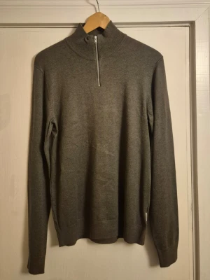 Grön quarter zip - Säljer en helt oanvänd grön/mörkgrön quarter zip från Lindbergh. Den är S men är lite stor