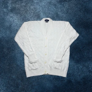 Ralph Lauren kabelstickad button up kofta - herr strl L - Säljer en vit Ralph Lauren kabelstickad button up kofta i storlek L med fickor vid midjan på varsin sida.  👕 Märke: Ralph Lauren 📏 Storlek: L 🎨 Färg: Vit 🧵 Material: 100% bomull 📐 Mått: 73 cm lång, 60 cm bred 📌 Skick: Mycket bra skick (se bilder)  💬 Hör av dig vid frågor 💰 Pris kan diskuteras vid snabb affär 📦 Skickas inom 24 timmar