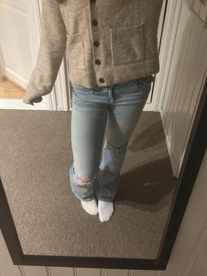 Ljusblå slitna jeans med hål - Säljer ett par ljusblå lågmidjade bootcut jeans ifrån Gina tricot, med konstgjorda hål på knäna. De är sparsamt använda och säljer så jag har för mycket jeans helt enkelt💕