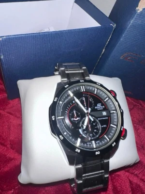 Casio Edifice svart klocka i stål - Snygg Casio Edifice herrklocka med svart urtavla, silverfärgat armband i rostfritt stål och röda detaljer. Klockan har flera små urtavlor och tydliga markeringar. Perfekt accessoar för dig som gillar sportig och stilren design.