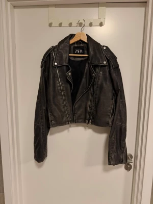Svart croppad skinnjacka från Zara - Ännu en jacka jag tyvärr inte använder så mycket som jag borde pga så snygg! Väldigt gott skick, sparsamt använd! Snygga detaljer med dragkedjor, croppad. Köpt i XXL för att få den lite extra oversize. Skulle säga att den är tts. 