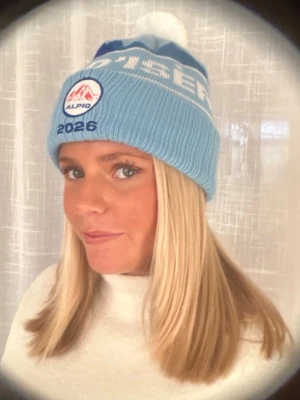 Blå skidmössa Val d'Isère - Skidmössa i en ljusblå färg med trycket ”Val-D'Isere” från Alpiq UF. Finns även i en mörkblå färg, kolla min profil för den annonsen. / ALPIQ UF 🩵