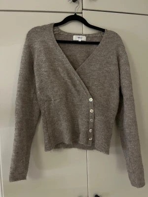 Stickad omlott tröja - Säljer denna söta stickade tröjan, mycket bra skick. Säljer då den inte kommer till användning.🤗 färgen är lite mer beige brun i verkligheten.