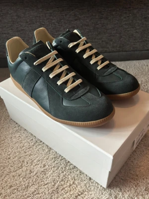 Maison margiela gats - Säljer ett par stilrena Maison margiela gats perfekt nu till våren • Storlek: 43 • Box + dustbag ingår • Skon är i ett mycket bra skick men boxen är lite sönder • Det är bara att slå en pling om du undrar något 