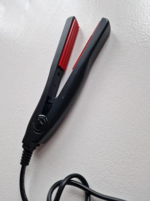 cera volumini/ volym tång - Elektrisk mini våffeltång med svart kropp och röda våfflade plattor. Perfekt för att skapa textur och volym i håret. Plattor 1,3 X 6cm Tångens längd till sladdfäste 15cm Blir 200 grader. https://lyko.com/sv/cera/volumini?gad_source=1&gad_campaignid=16712307277&gclid=EAIaIQobChMI4aySiJSSkgMVIhiiAx2dyTxREAQYASABEgJ1OfD_BwE