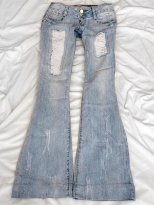 Ljusblå superlågmidjade jeans med slitningar - Sååå sjukt snygga vintage superlågmidjade jeans med slitningar!😩😩💓💓säljer eftersom de inte passar därför har jag ingen bild på! 💓   Innebenslängd: 76 midjemått: 36