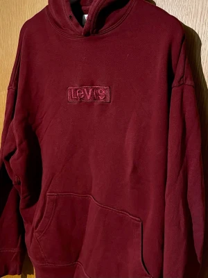 Levis hoodie - Märke: Levis | Passform: Regular | Storlek: L (passar även M) | Färg: Vinröd | Skick: 6/10 | Defekter: Inga större men saknar snören och är lite solblekt, annars fin. Kom gärna med frågor!