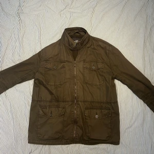 Grön Field Jacka - Hej! Jag säljer nu min oliv gröna Field jacka då jag har köpt en ny. Jackan är inom ett gott skick och är perfekt inför våren och sommaren! Inga defekter på jackan. Vid minsta fråga, tveka inte till att skriva!