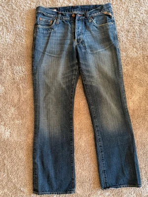 Vintage bootcut jeans från jack&jones - Säljer dessa snygga vintage jeansen från jack&jones. Passformen är bootcut och de har sjukt snygg wash. Storlek 31/32. Midja 41cm, innerbenslängd 76cm, benöppning 23cm