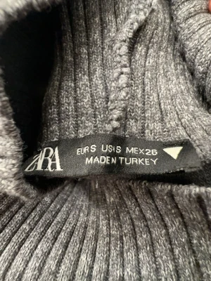 Zara Grå stickad Polo topp - Säljer en grå stickad väst från Zara med hög ribbad krage och ärmlös design. Perfekt nu inför våren 🤩💐 använd några gånger men är i väldigt fint skick! Säljer pågrund av att den inte kommer till användning, skicka vid fler frågor annars är det bara att köpa 🌸