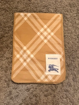 Burberry halsduk  - Säljer en stilren Burberry-halsduk i det klassiska rutmönstret. Väldigt clean färg i beige/kamel som passar till nästan alla outfits. Perfekt till lite kallare kvällar!