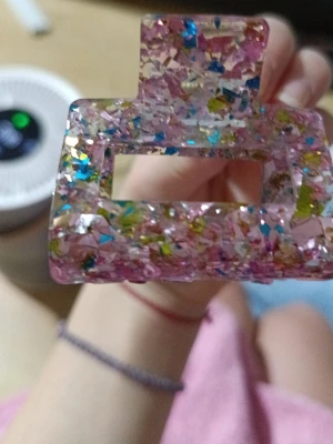 Färgglad hårklämma i akryl - Säljer en rektangulär hårklämma i transparent akryl med inslag av rosa, blått, gult och silverglitter. Klämman har en trendig chunky design och passar perfekt för att sätta upp håret på ett snyggt sätt.