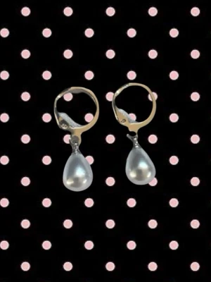 Silverörhängen med pärldroppar - Snygga örhängen i silverfärg med droppformade pärlor som hänger från små ringar. Perfekt för dig som gillar klassisk och stilren design med en touch av elegans. Passar till alla tillfällen och ger en lyxig känsla till din look.