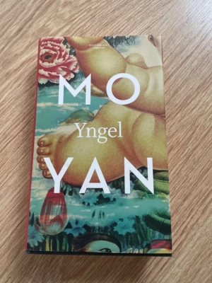 Yngel av Mo Yan - Romanen 'Yngel' av Mo Yan har ett färgstarkt omslag med konstnärlig illustration i grönt, rött och beige. Boken är i pocketformat och utgiven av Bokförlaget Tranan. Perfekt för dig som gillar modern skönlitteratur från internationellt känd författare.