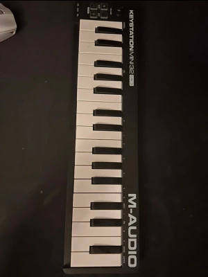 M-Audio Keystation Mini 32 MK3 MIDI - Säljer ett M-Audio Keystation Mini 32 MK3 MIDI-keyboard som är relativt nytt och oanvänt. Det är svart med vita tangenter och har 32 smidiga tangenter, volymratt, oktavknappar och pitch/mod-knappar. Perfekt för musikproduktion och kompakt nog att ta med överallt.