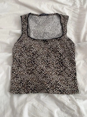 Leopardmönstrad topp - Säljer en leopardmönstrad linnetopp. Toppen är ärmlös och har fyrkantig ringning. Knappt använd. 