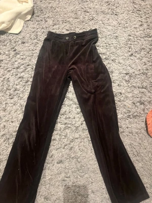 Svarta velourbyxor från Gina Tricot - Mysiga svarta mjukisbyxor i velour från Gina Tricot. Byxorna har utsvängda ben, resår i midjan och dragsko med två metallöljetter. Perfekta för en chill och avslappnad stil.