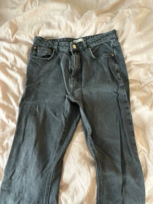 Gina Tricot booutcut jeans - Svart/gråa Jens från gina. Hög midjade booutcat. Med slits på benen. Storlek M. Andvända några gånger💕