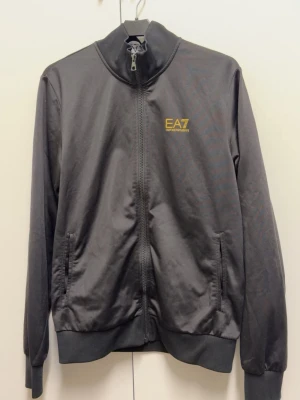 Svart ziptröja från EA7 Emporio Armani - Schysst tröja i mjukt material. Knappt använd. Storleken är s men det står ingen lapp i.