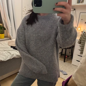 Grå stickad tröja från H&M -  grå stickad tröja från H&M i en mjuk ull- och alpackablandning. 