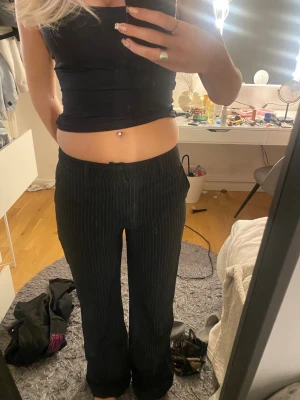 Randiga kostymbyxor - Säljer ett par svarta  kostymbyxor som är randiga. Byxorna har rak passform lite bootcut och normal midja. Perfekta för en clean och stilren look. De är i längden regular och till marken på mug som är 175