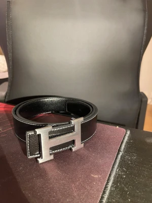 Fet bälte - Säljer ett bälte med färgen svart och bokstaven H på framdelen. Varan är i nytt skick