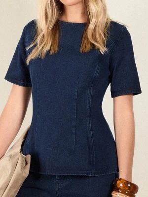 Mörkblå denim topp med kort ärm - Snygg mörkblå topp i denim-look med figurnära passform och korta ärmar. Toppen har rund halsringning och markerade sömmar framtill som ger en modern siluett. Säljer pga att den inte kommer till användning jätte fint skick!