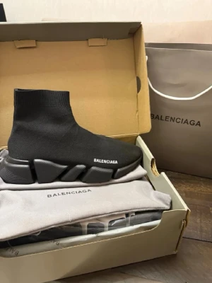Balenciaga - Svarta Balenciaga Speed Trainer sneakers med stickad strumpdesign och chunky sula. Skon har en minimalistisk look med vit Balenciaga-logga på sidan och är tillverkad i stretchigt textilmaterial för en tight passform.