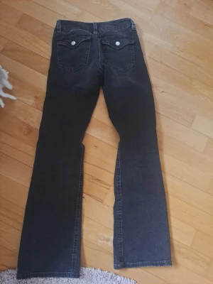 Svarta bootcut jeans från Gina Tricot - Bootcut jeans i svart denim från Gina Tricot (young) med klassiska femficksdetaljer och vita knappar på bakfickorna. Jeansen passar till mycket och är i storlek 158. Säljer då de är för korta. Skriv vid intresse 💗