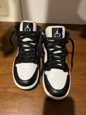  Air Jordan 1 mid - Säljer ett par klassiska Air Jordan 1 mid i svart och vitt läder. 
