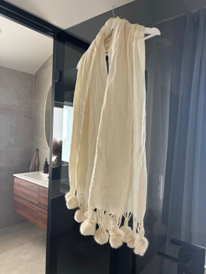 Krämvit sjal med fluffiga bollar - Halsduk ifrån Hollies