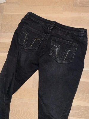 Svarta bootcut jeans med detaljer - Säljer ett par svarta bootcut jeans med snygga fickdetaljer. De är från gina 14+ i storlek medium och passar mig som brukar ha 36 i jeans. 
