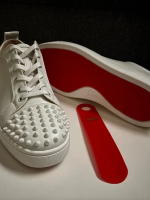 Vita Loubs med spikar - (pris kan diskuteras) Jag säljer nu helt nya vita Loubs med spikar. Skorna är i perfekt kondition, skorna har bara prövats men dom var för stora, så jag säljer dom nu till ett väldigt bra pris. (Det på bilderna är det som ingår, alltså skorna + skohornet. Inte box eller små grejer)