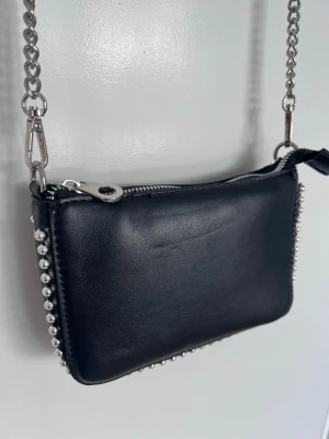 Svart it-girl Y2K axelremsväska med kedja & studs, ny - Mindre axelremsväska med kedjerem i silver och studsdetaljer - 00s baddie/it-girl känsla!!  Smidig storlek – rymmer mobil, kort & läppglans. Bandet kan kortas lite genom att fästa det som på näst sista bilden! Statement piece som lyfter hela outfiten.
