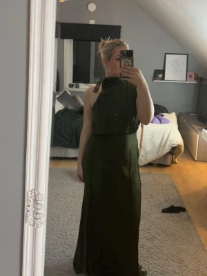 Mörkgrön långklänning med knyt - Snygg balklänning i mörk grön färg, storlek M men kan passa S också. Säljer då den va för stor, aldrig använd. Prislappen är  kvar.❤️