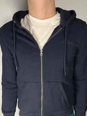J.Lindeberg ziphoodie - Säljer en riktigt snygg och trendig J.Lindeberg zip hoodie i fint skick, storlek M men sitter som S, vid frågor är det bara att skriva //Gramenti