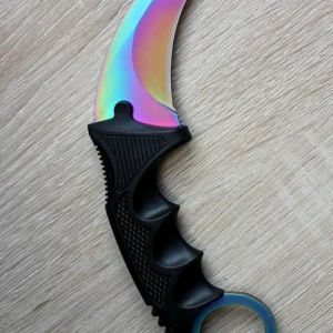  karambit fade - Säljer en karambitkniv med regnbågsskimrande böjt blad och svart ergonomiskt handtag i plast. Perfekt för samlare eller cosplay. Bladet har en cool metallisk finish som skiftar i färg beroende på ljuset.