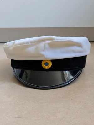 Student mössa - Student mössa köpt år 1990.  Bild sju visar namn lappen som ska sitta på insidan av mössan. Den har dock ramlat av, limmet har släppt. Det går snabbt och enkelt att limma tillbaka den. Jag kommer att skicka med namnlappen tillsammans med student mössan.