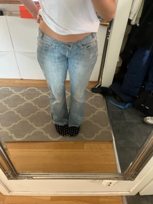 Ljusblå bootcut jeans med låg midja - Säljer dessa snygga jeans som är väldigt lågmidjade! Har lagt dit extra knappar då de va lite stora i midjan, men går ju att välja själv vilken knapp man vill knäppa i för att justera storleken 💕💕 står size 30 i men skulle säga att de sitter som S/M