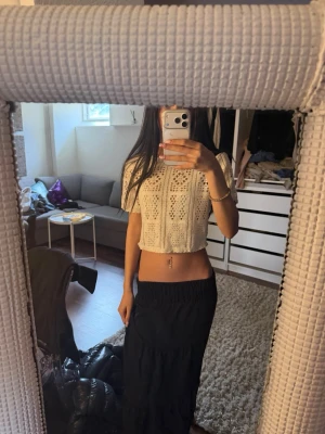 Beige virkad croppad topp - Superfin beige croppad topp med virkat mönster och korta ärmar. Perfekt för varma dagar och ger en chill och trendig vibe. Toppen har en lös passform och är tillverkad i bomull, vilket gör den både bekväm och luftig.