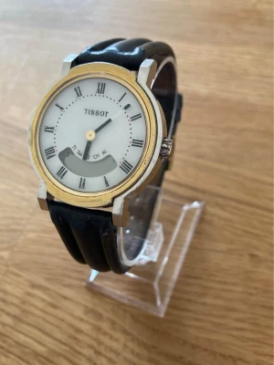 1980 Tissot Ana-Digi 38mm Herrur - Säljer en ovanlig men snygg vintage herrklocka från Schweiziska Tissot i mycket fint skick enligt bilder. Okänd funktion, armband i äkta läder, digital, vattentät, osv. Behöver förmodligen service. Fås i rejäl stötskyddande box klädd i skumgummi.   Begagnat värde: < 2000 SEK Mitt pris: 989 SEK  Skickas alltid snabbt och spårbart. Skriv vid frågor och se gärna mina andra annonser!   GRATIS: För återkommande kunder erbjuder jag personlig experthjälp för dig att göra nya fynd (nytt & begagnat).