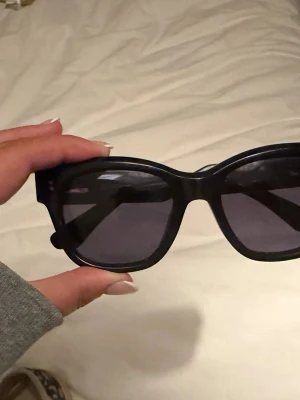 Svarta  solglasögon från chimi  - Säljer ett par svarta solglasögon med breda bågar och mörka glas. De har en futuristisk och sportig vibe med rektangulär form och markerad näsbrygga. Perfekta för dig som vill sticka ut med en cool accessoar.