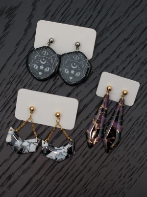 Handgjorda örhängen i polymerlera och stift i rostfritt stål svart lila guld katt  - Handgjorda örhängen i polymerlera och stift i rostfritt stål.  Självklart nya och oanvända. Storlek: Katter 3x4cm. Avlånga 1,5x5,5cm. Svart/vita med kedja 3x4,5cm.  Färgerna kan variera beroende på skärminställningar.