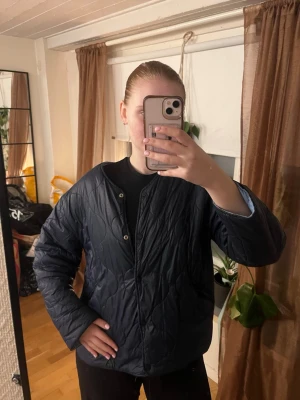 Vändbar quiltad jacka i mörkblå och ljusblå - Snygg vändbar quiltad jacka med ena sidan i ljusblått och andra i mörkblå. Tillkommer extra knappar till båda sidorna 