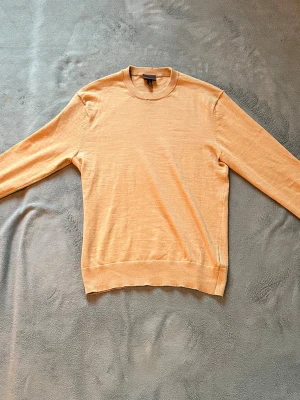 Beige tröja - En stilren beige tröja med rund halsringning och långa ärmar. Tröjan är tillverkad i ett tunt, mjukt material som ger en avslappnad passform. Perfekt för lager på lager och enkel att matcha med olika outfits.