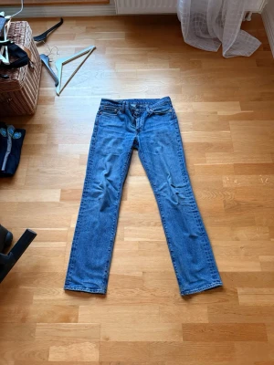 Levi’s 514 - Klassiska blå jeans från Levi's med rak passform och fem fickor. modell 514. Jeansen har en tidlös look med knappgylf och nitar i kopparfärg. Tillverkade i slitstark denim som passar perfekt till en avslappnad stil. Finns liten skada längst ner vid foten, syns på bild. 